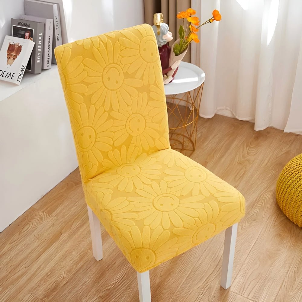 Lemon Zest Blossom Aura stretch chair cover in floral fabric with elastic fit, displayed on a dining chair in a home setting.