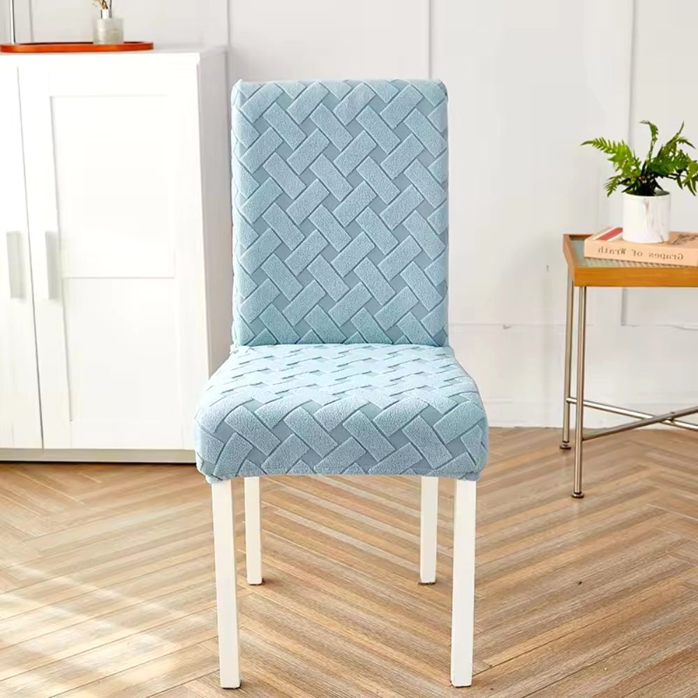 Haven Weave Jacquard Chair Cover in Sky Mist Blue, showcasing an elegant woven pattern, fitted on a dining chair in a contemporary room setting.