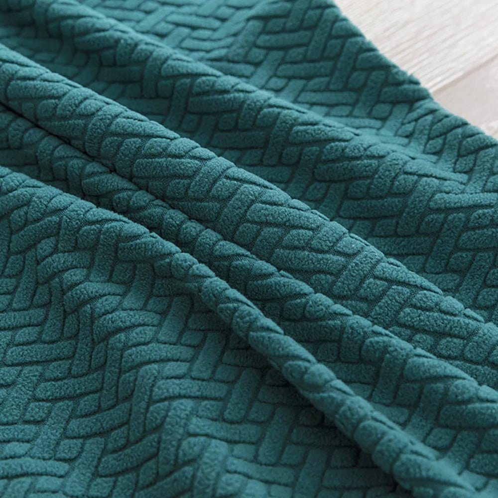 Close-up view of the teal blue Veluxe Haven Jacquard Velvet Dining Chair Cover, highlighting its textured, stretch-fit fabric and intricate pattern.