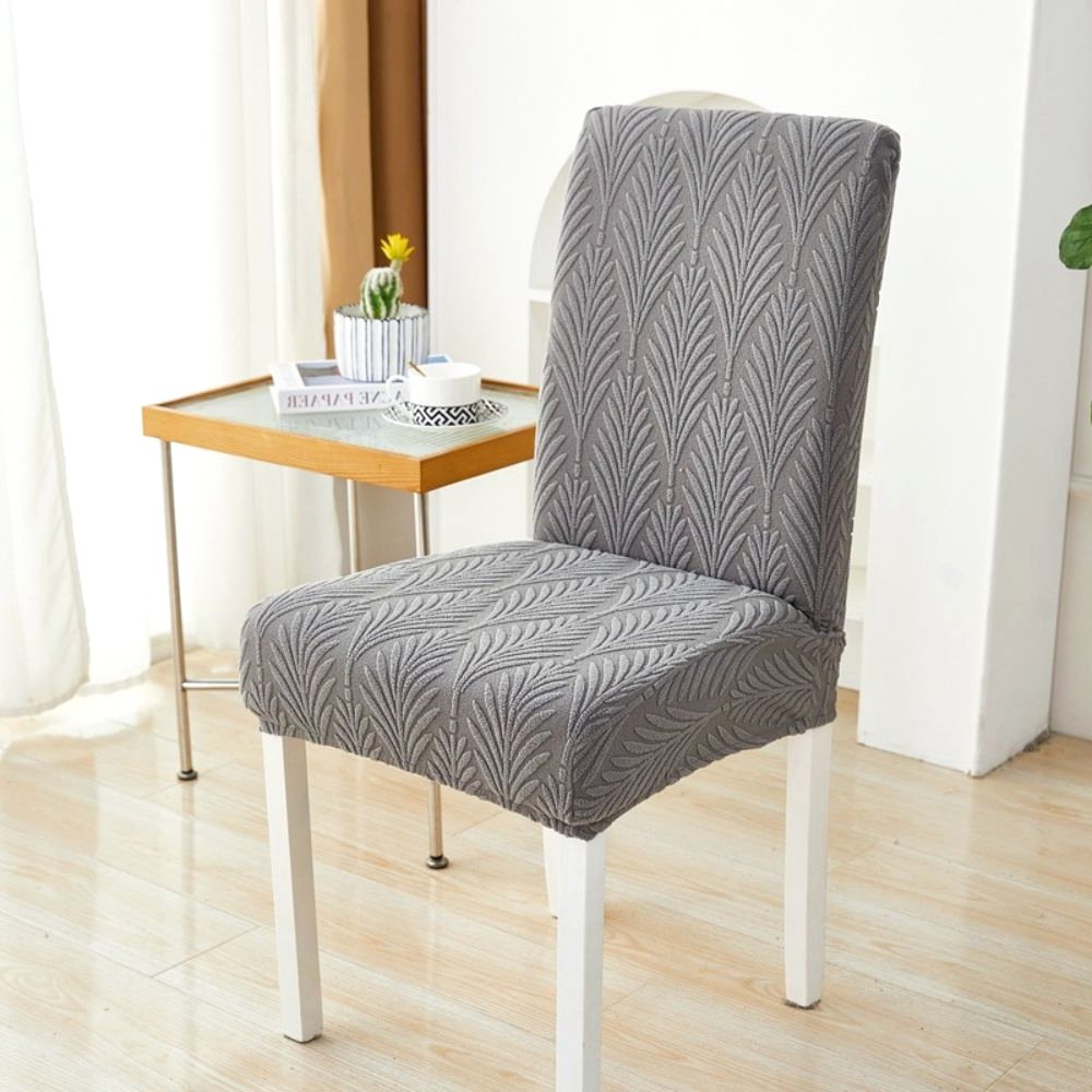 Charcoal Gray Palm Weave Elastic Jacquard Chair Cover on a dining chair, showcasing its stretch fit and elegant design in a home setting.