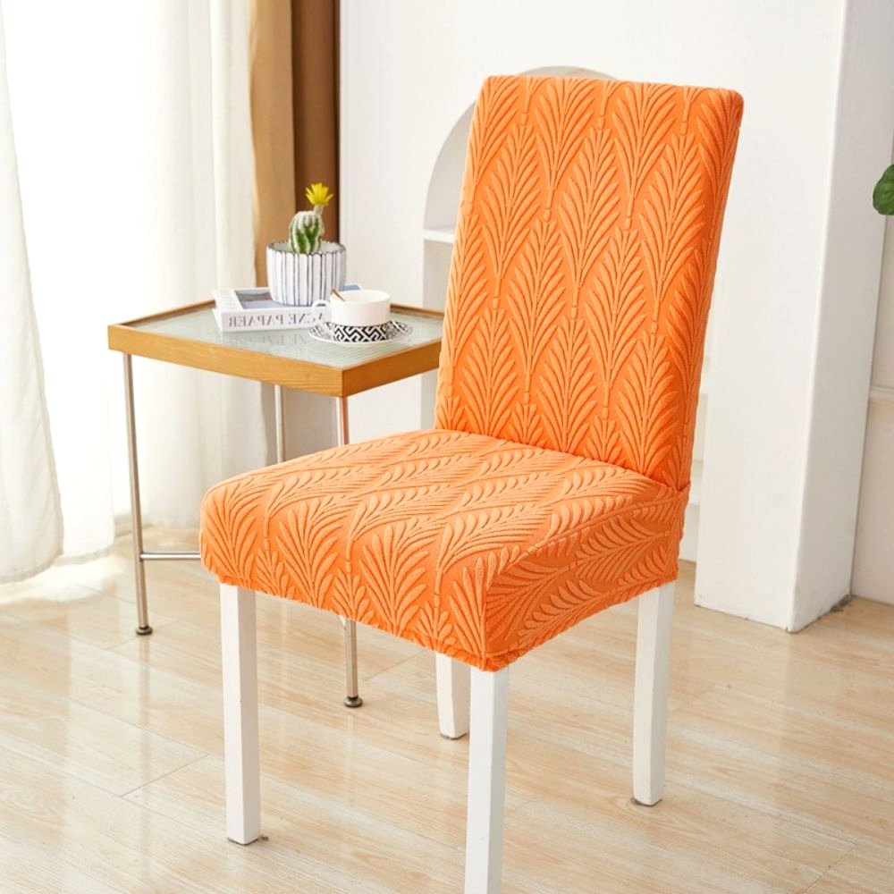 Velvet Haven Elastic Jacquard Chair Cover in Sunset Orange with Palm Weave pattern, showcasing its stretch fit on a dining chair. Adds tropical modern touch home decor.