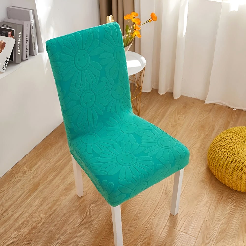 Teal Breeze Blossom Aura stretch chair cover in floral fabric with elastic fit, displayed on a dining chair in a home setting.