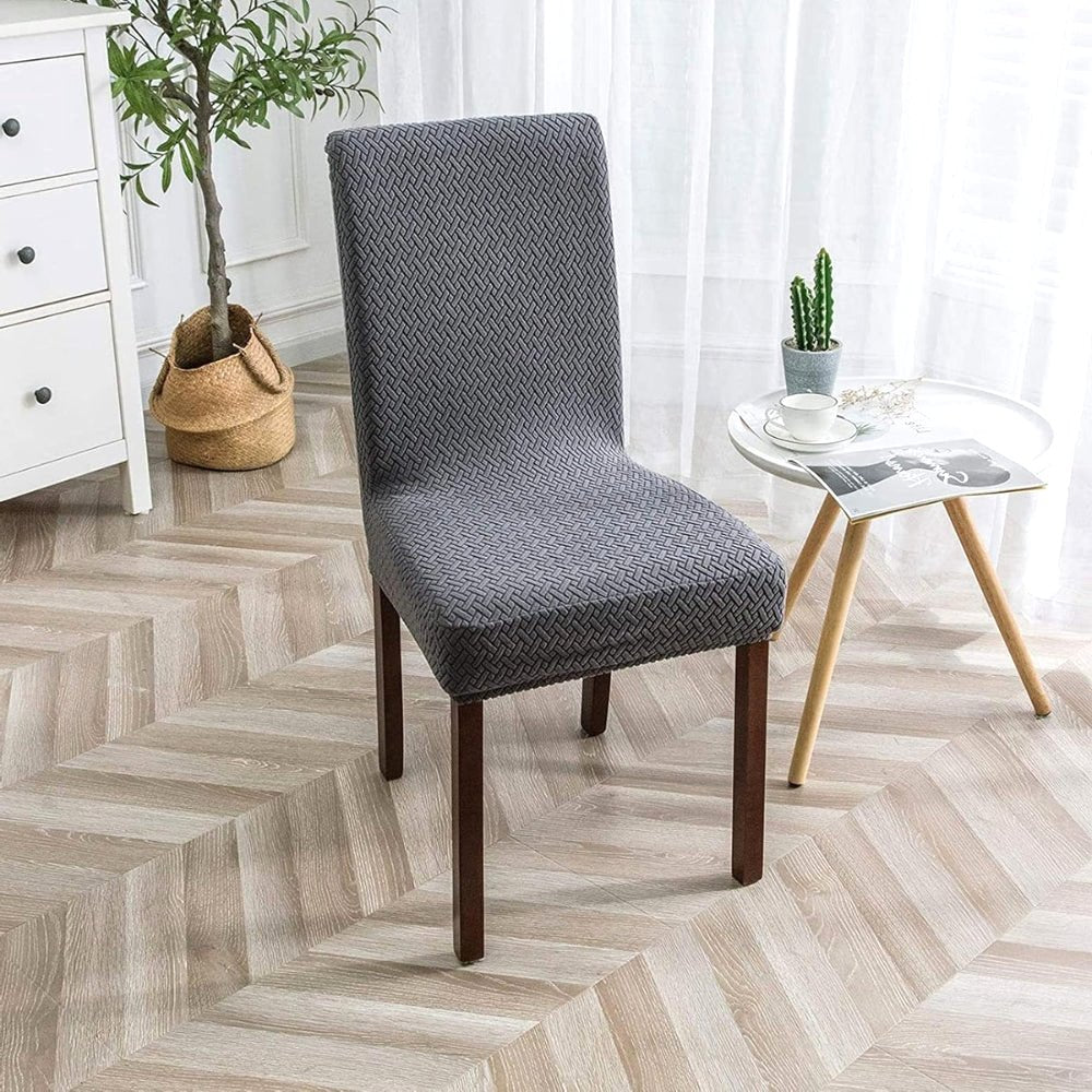 An ash gray Veluxe Haven Jacquard Velvet Dining Chair Cover on a dining chair, showcasing its stretch fit and elegant texture in a modern dining room setting.