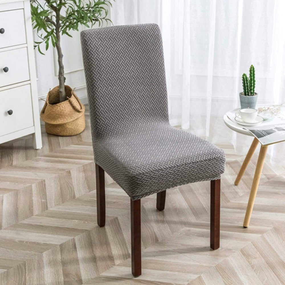 Ash Gray Veluxe Haven Jacquard Velvet Dining Chair Cover with Stretch Fit, showing its neutral tone and intricate jacquard pattern on a dining chair in a bright room.