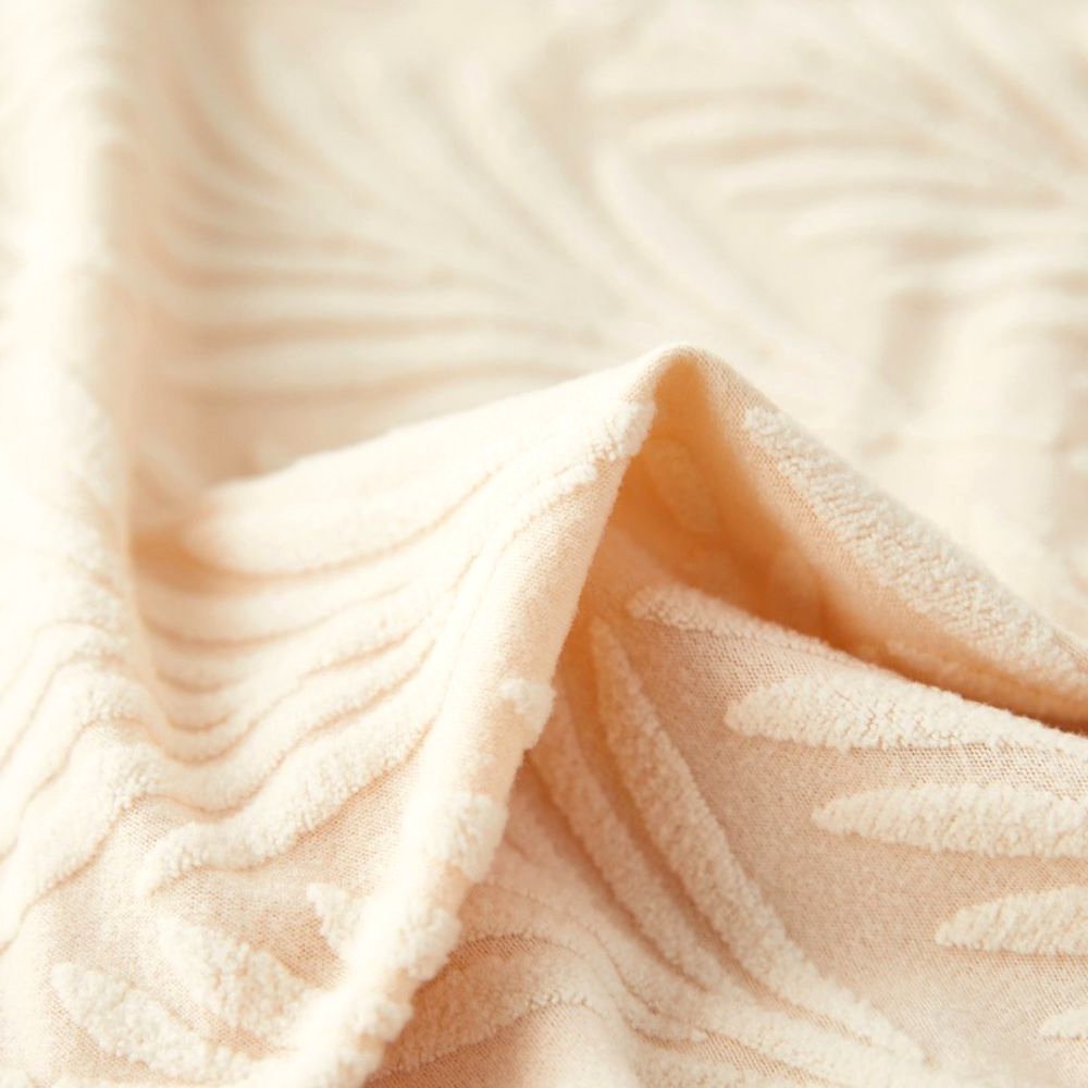 Close-up view of the soft white Velvet Haven elastic jacquard chair cover fabric, showing its textured palm weave pattern and material quality.