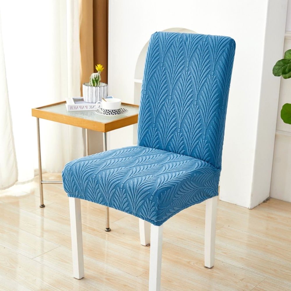 Velvet Haven Elastic Jacquard Chair Cover in Ocean Blue Palm Weave pattern, shown on a white dining chair. This stretch fit furniture protector offers a modern design and easy installation.